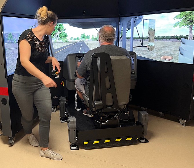 A new simulator at WNC Fallon will help prospective drivers earn their CDL. Lauren Slemenda, left, assists a student.