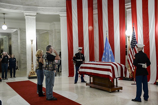 People salute the casket of Hershel ‘Woody’ Williams set up in the first floor rotunda of the West Virginia State Capitol in Charleston, W.Va., on July 2, 2022.