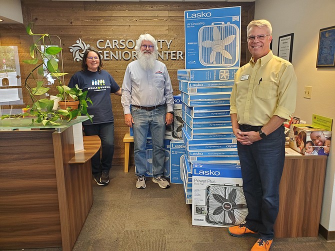 Courtney Warner (left), executive director, and Michael Salogga (right), business manager of the Carson City Senior Center receive another 27 new fans from Dirk Roper (center), owner of Roper’s Heating and Air Conditioning to be distributed to Carson City seniors through the KOLOCares Fan Drive.