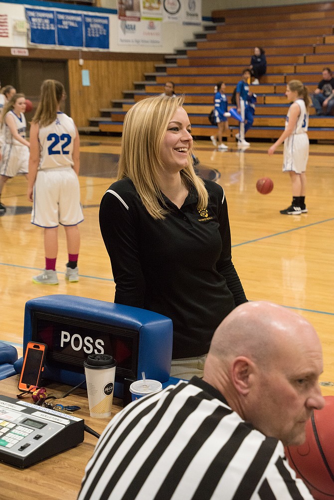 Tiffany O'Day, a 2009 Carson High alumna, smiles at the scorer's table at Carson High while coaching the Galena girls basketball junior varsity team.