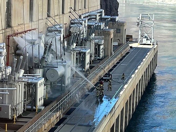 Firefighters extinguish a fire at the Hoover Dam on July 19, 2022 near Boulder City.