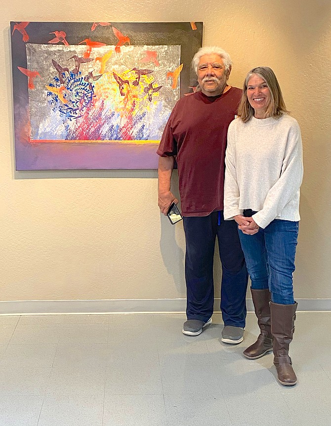Jack Malotte, left, pictured with Marie Nygren, is currently exhibiting his artwork at the Western Nevada College Fallon campus. He is with his with his painting ‘Fighting Hummingbirds.’