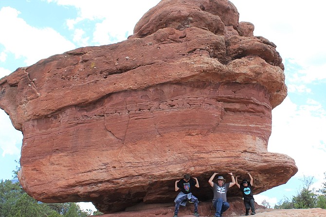 On the recent Warther Tour to see Colorado’s Trains and Parks, Art Erickson (center) helped Tannir and Colton Roush hold up the Balance Rock in the Garden of the Gods.