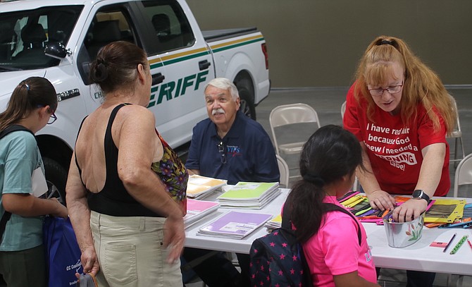 Tom, left, and Brandy Goodson from the Fallon Police Department’s Volunteers in Policing hand out school supplies on Saturday at Fallon Community Days.