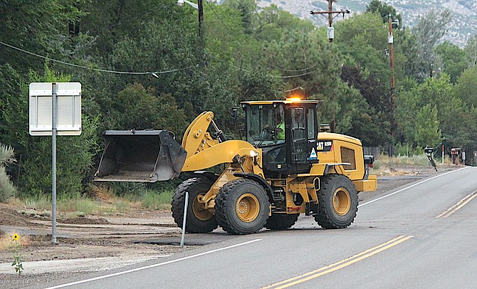 A Douglas County front loader clears mud off of Diorite and Foothill Road on Friday morning.
