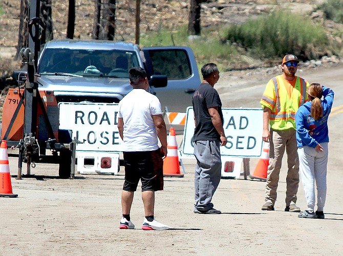 A CalTrans worker talks to people who pulled up to the barricade at the northwestern entrance to Markleeville on Saturday.