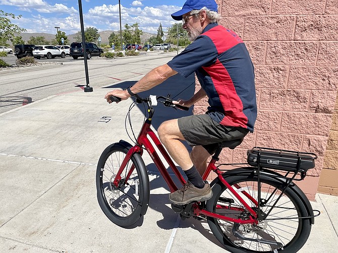 Denis Coyne, owner of Bike Habitat, takes a new ebike out for a spin off Topsy Lane on Aug. 10, 2022.