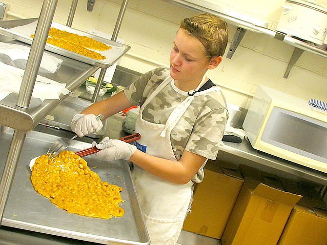 Thirteen-year-old Molly Wilson removes peanut brittle from a tray Friday.