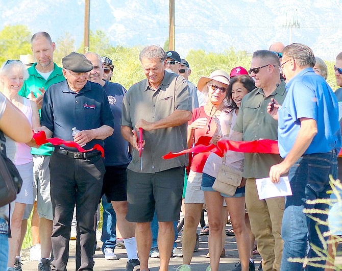 Douglas County Commissioner Danny Tarkanian mans the big scissors as town and county officials look on at the Martin Slough Trail dedication in Minden on Saturday.