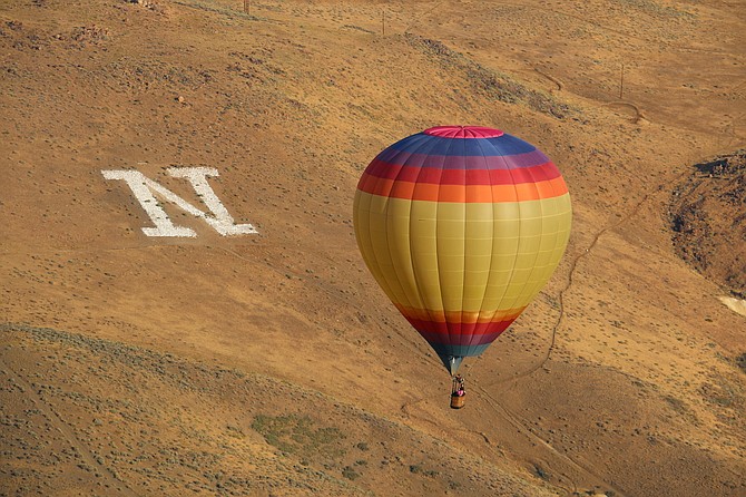 A balloon slowly descends near Peavine Mountain above the University of Nevada, Reno’s “N" on Sept. 8, 2022.