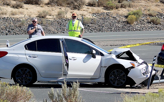 A white sedan has its front end crunched after a multiple vehicle collision on Highway 395 just south of Topsy Lane.