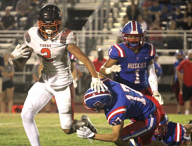 Douglas High’s Trace Estes stiff-arms a Reno defender for extra yards Friday at Reno High. Estes has been the Tigers’ leading wide out this season with 170 yards receiving.
