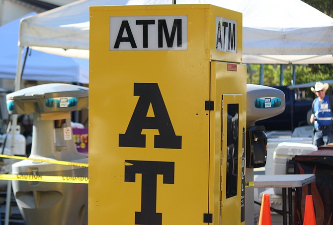 One of the many ATMs with an escort of hand washing stations stands in front of the Genoa Town Hall on Friday morning. Visitors and vendors may find Wi-Fi scarce in the oldest town during Candy Dance.