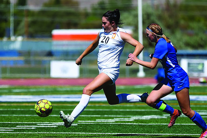 Douglas High’s Aleeah Weaver dribbles around a Carson defender Saturday. Weaver scored both goals in the Tigers’ 2-0 win.