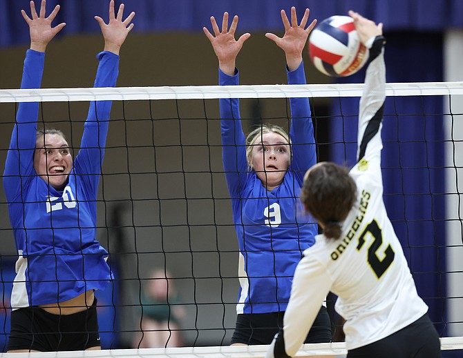 Carson High's Sarah Miller (20) and Josie Nerska (9) go up for a block against Galena Tuesday night.