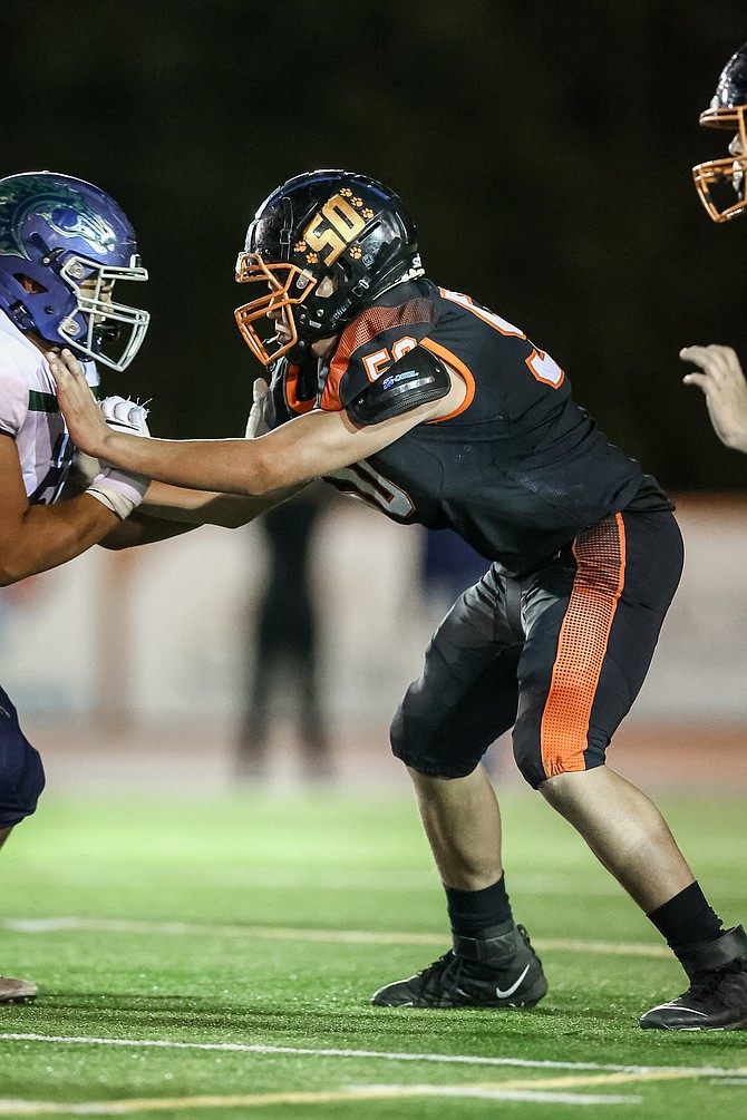 Douglas High’s Austin Pitts (50) fights through a block for the Tigers against Damonte Ranch. Pitts and the rest of the Tigers will travel to Carson High on Friday in hopes of returning The Rivalry Trophy to Douglas High School.