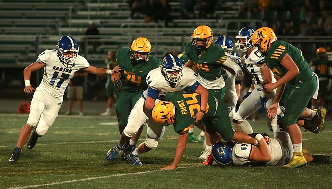 Carson High’s Nate McKee wraps up a Bishop Manogue ball carrier last week. McKee and the Senators are preparing for Douglas High on Friday.