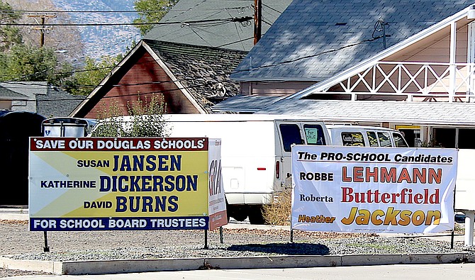 Signs for the two school board trustee tickets are side by side in Gardnerville on Tuesday.