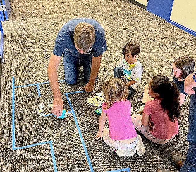 Elks volunteer Gary Beadle working with several students to code a robot to navigate a particular path while avoiding obstacles.
Photo special to The R-C