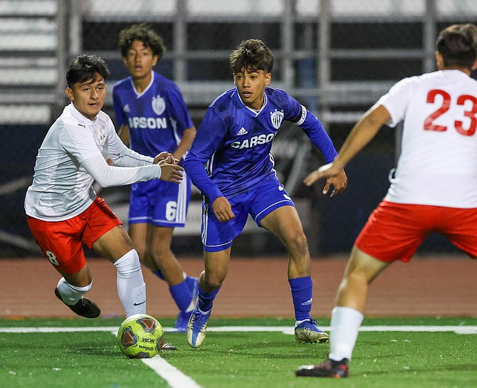 Carson’s Angel Vega looks for a pass under heavy pressure from Wooster defenders during the game between the Wooster Colts and the Carson High Senators.