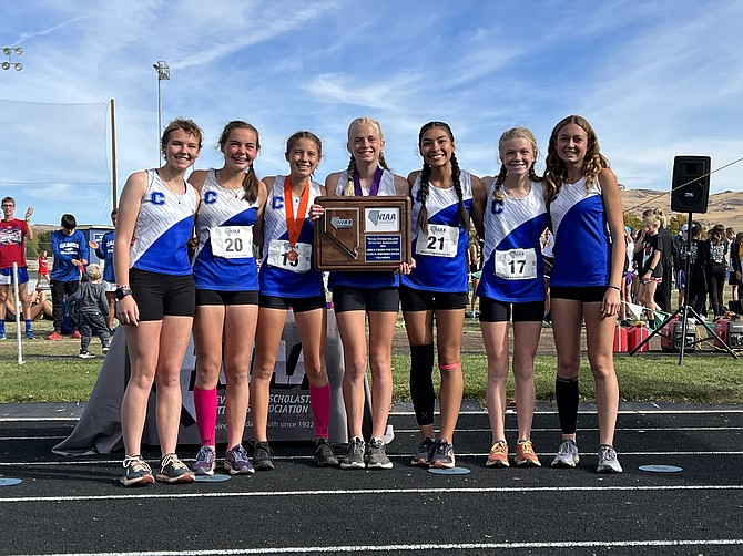 The Carson High girls cross country team poses with the Class 5A regional championship trophy Friday afternoon at Reed High School. Pictured from left to right are Eleanor Romeo, Jinnie Ponczoch, Hannah Budd, Vea Miner, Brianna Rodriguez-Nunez, Madison Hager and Ella Dooley.