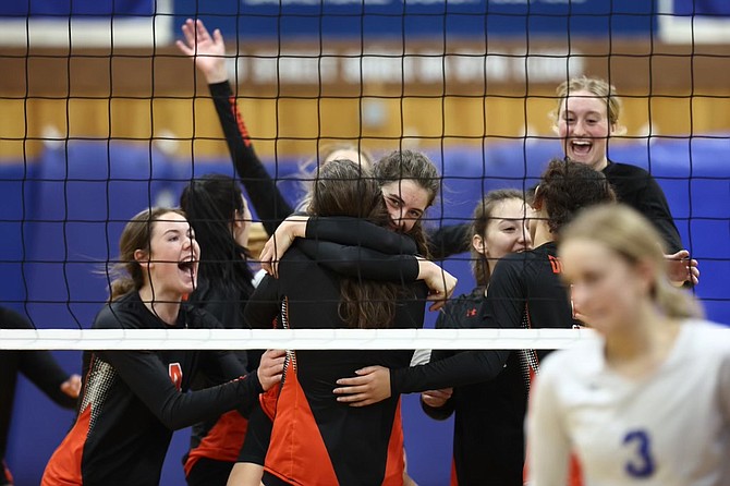 The Douglas High volleyball team storms the court after defeating Carson High in the opening round of the Class 5A North regional playoffs.