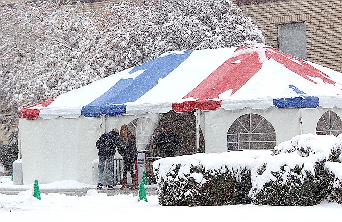 Two voters drop paper ballots at the Election Tent behind the Douglas County Courthouse in Minden. Stormy weather prompted the Clerk-Treasurer's Office to move voting machines indoors on Election Day.