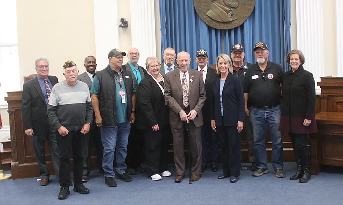 Previous Veterans of the Month surround longtime Nevada Department of Veteran Services board member William “Bill” Baumann, center, and outgoing Nevada Secretary of State Barbara Cegavske during a recent ceremony at Old Assembly Chambers on the Capitol complex in Carson City.
