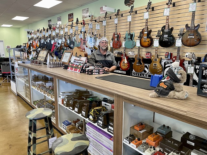 Curt Dony in front of his guitar selection at C.C. Top Music, Arts, and Beyond on Nov. 15. He sells new and used vintage guitars.