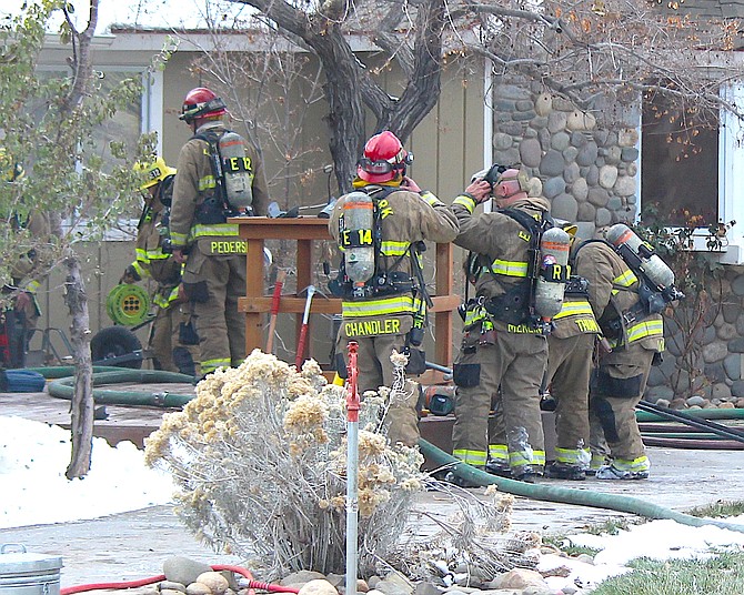 Firefighters gather outside a home on Meadowlark Circle after fighting a chimney fire in a home on Thursday afternoon.