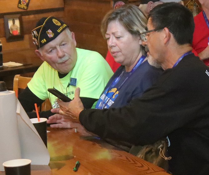On their recent Honor Flight, Diana (center) and Salvador Pleitez (right) share their story of their son, Benjamin, to a member of the American Legion in Maryland.