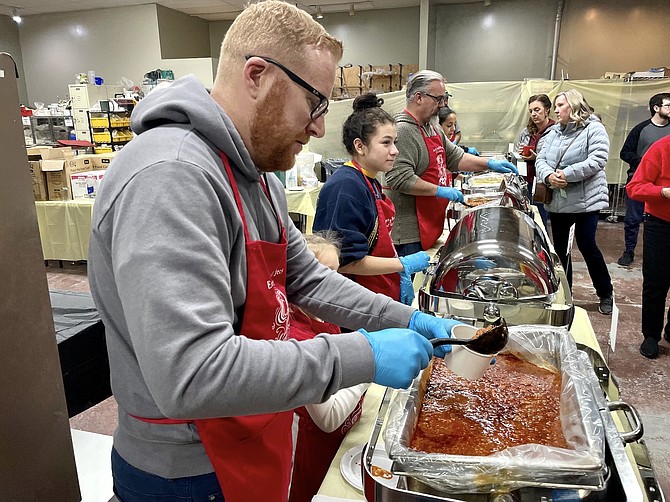 Volunteer Andrew Kapczynski dishes out chili at the Empty Bowls fundraiser Dec. 2.