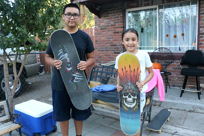Sparks skateboarding enthusiasts JoJo Flores, 14, and his sister, Milinda Flores, 8, show the boards repaired or replaced for them as an act of kindness by Carson City shop owner Matt Barrtak after learning they had lost their grandfather in September.