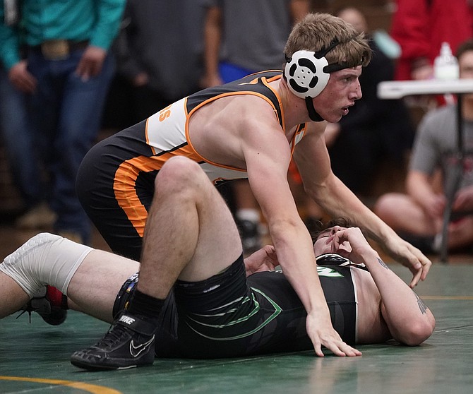 Jackson Nixon looks up after a pin in a match last winter. This season, Nixon will be one of three captains on the Douglas High wrestling team.