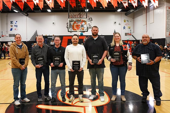 Seven of the eight newest members of the Douglas High basketball Hall of Fame pose with their plaques after being selected Saturday, following the Tigers’ win over Woodland Christian. Pictured from left are Julie Gingrich, Dave Pfaffenberger, Chris Downs, Mike Gransberry, Keith Olsen, Jessica Waggoner and Frank Pitts. Not pictured is Bridget Maestretti.