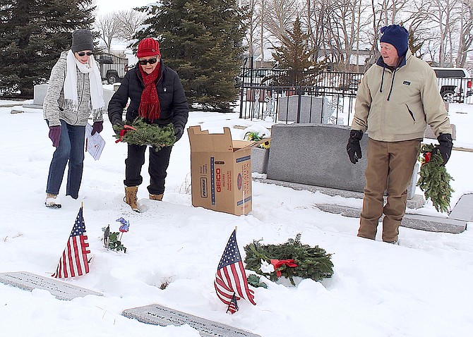 Ursula McManus, Kathryn and Tom Zogorski place wreaths on veterans’ graves at Mottsville Cemetery on Saturday.