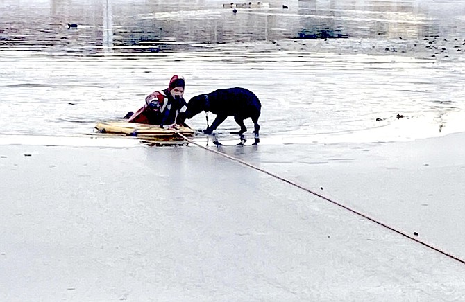 A grateful pup greets a firefighter as he's pulled back onto the ice after a rescue in the Ranchos on Tuesday. East Fork Fire Protection District photo