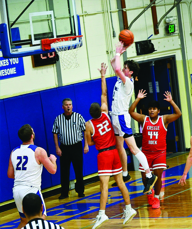 Eatonville’s Shay Brannon rises above Castle Rock’s Owen Langdon (22) and David Garcia (44) to score two of his game-high 24 points in the Cruisers’ 70-57 win.