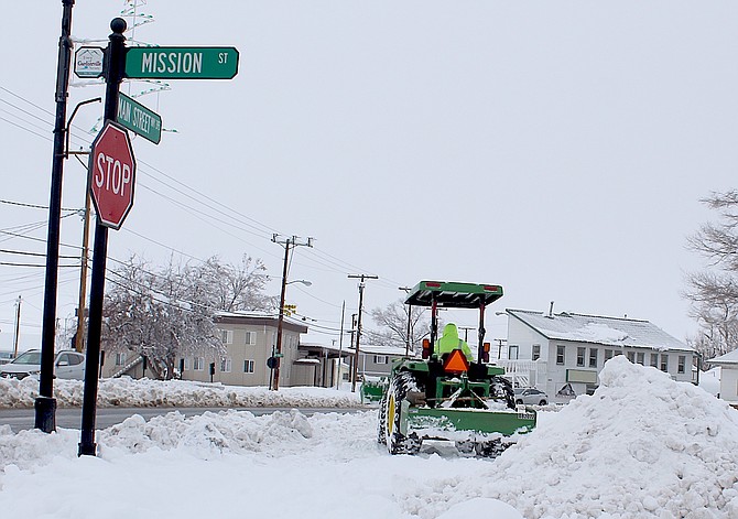 A tractor plows the parking lot of Gardnerville Station in the S-curve.