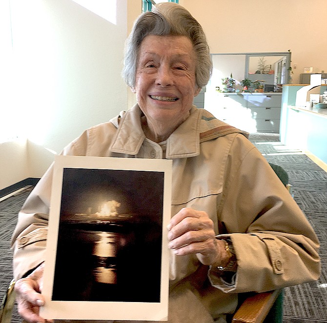 Dorothy Uebele with a photo of a rocket launch that her husband George worked on.