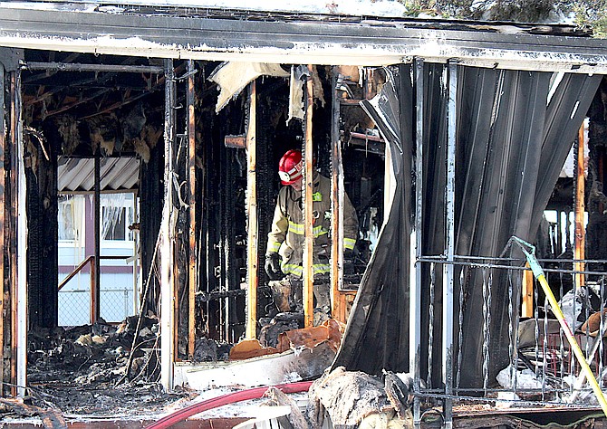 An East Fork firefighter checks on the interior of a home on Bishop's Circle in Kings Lane on Saturday morning.