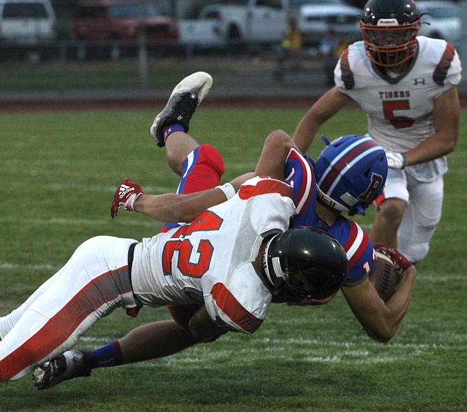 Douglas High's Cole Smalley (42) makes a tackle against Reno this past fall. The Tigers' appeal to move from Class 5A to 3A was denied by the NIAA realingment committee Monday morning.