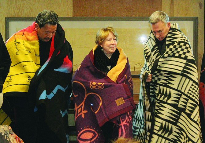 From left: Seattle Mayor Bruce Harrell, District 4 County Councilmember Jeanne Kohl-Welles and King County Executive Dow Constantine wear the ceremonial blankets presented to them at the blessing for the future United Indians of all Tribe Foundation’s Native Northwest Canoe Carving House at the Center for Wooden Boats next to South Lake Union.