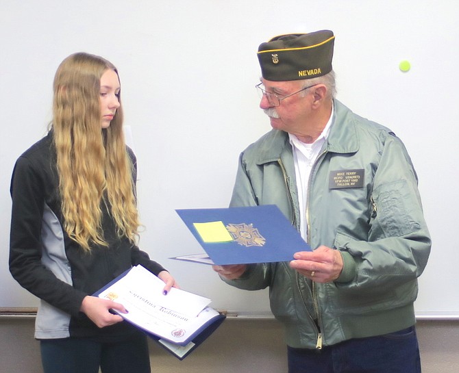 Veterans of Foreign War member Mike Terry, who is stepping down as the local Voice of Democracy and Patriot’s Pen contest chairman, presents a certificate and monetary awards to Christina Robinson of Oasis Academy. She placed first in District 4 and second in state.