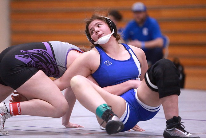 Carson High’s Ellah Olson reaches her arm back to start her reversal in the girls 152-pound regional final Saturday at McQueen. Olson earned a regional title after pinning her opponent in 4:45.