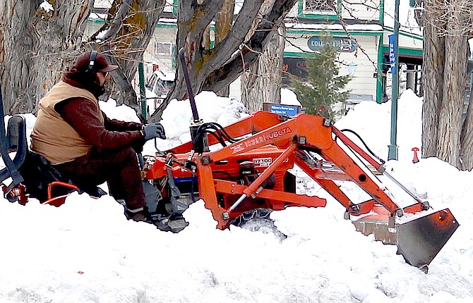 A worker works to clear the parking lot at Mormon Station State Historic Park on Saturday.