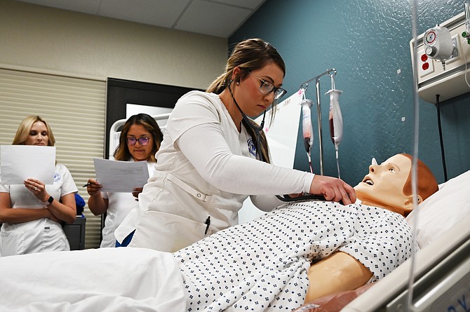 Western Nevada College nursing students participating in a lab are Paige Thorn (assessing mannequin), Jessica Camacho (left) and Taylor O'Daye (right).