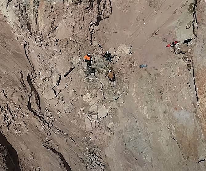 Workers cling to the rock face above Highway 208 in Wilson Canyon.