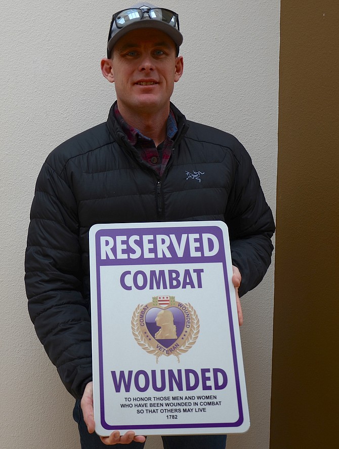 Western Nevada College Veterans Resource Center Coordinator John Jacobson displays a Purple Heart parking sign that will be used to designate parking spaces for disabled and handicapped veterans on Western’s three campuses.