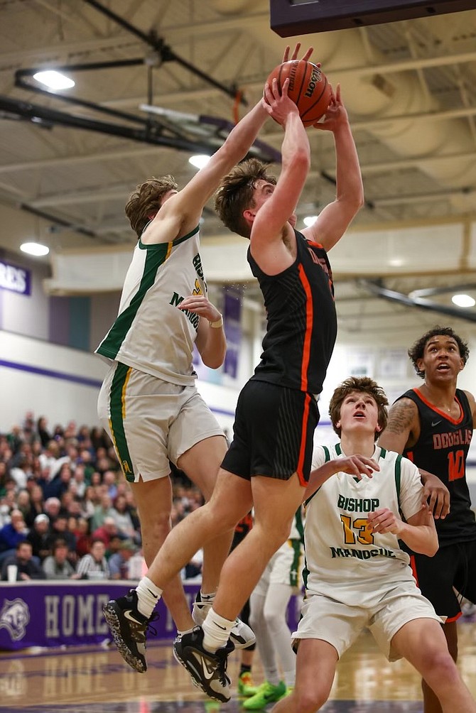 Douglas High's JC Reid goes up for a basket while a Bishop Manogue defender attempts to block his shot Saturday night at Spanish Springs. Reid finished with four points in the regional championship loss.